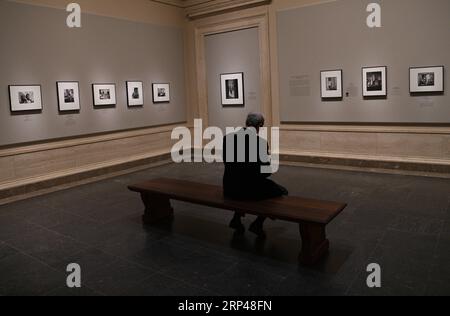 (181030) -- WASHINGTON, 30. Oktober 2018 -- Ein Mann sitzt während einer Vorschau der Ausstellung Gordon Parks: The New Tide, frühe Arbeit 1940-1950 in der National Gallery of Art in Washington D.C., USA, am 30. Oktober 2018. Die Ausstellung, die 150 Fotografien und Ephemeren zusammenbringt, konzentriert sich auf das prägende Jahrzehnt der 60-jährigen Karriere des amerikanischen Fotografen. Sie wird vom 4. November 2018 bis 18. Februar 2019 für die Öffentlichkeit zugänglich gemacht. ) U.S.-WASHINGTON D.C.-EXHIBITION-GORDON PARKS LIUXJIE PUBLICATIONXNOTXINXCHN Stockfoto