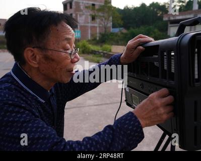 (181031) -- YUDU, 31. Oktober 2018 -- Zeng Jilian, ein 69-jähriger Filmprojektionist, testet die Filmprojektionseinrichtungen im Shanxia Village im Yudu County, ostchinesische Provinz Jiangxi, 30. Oktober 2018. Zeng Jilian hatte schon als Kind davon geträumt, Filmvorführer zu sein. 1975 wurde sein Traum wahr, als er Mitglied des Filmprojektionsteams von Kuantian Town im Yudu County wurde. Seitdem reiste er in verschiedene Dörfer und zeigte zahlreiche Filme für die Einheimischen. Obwohl Zeng nun pensioniert war, hielt er seine Karriere über 40 Jahre lang an und gab mehr als 20 Mal Vorführungen Stockfoto