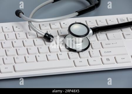 Stethoskop und Computertastatur. Medizinische Aufzeichnungen, Datensicherheit, Telemedizin und Telemedizin. Stockfoto