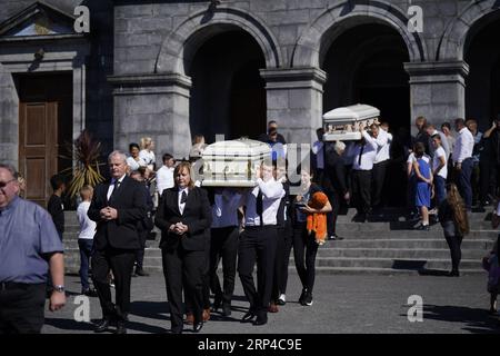 Diane Reilly (trägt oranges Spielzeug) geht hinter dem Sarg ihres dreijährigen Sohnes Tom, als die Särge von Thomas Reilly, 45, seiner Frau Bridget Reilly, 46, und Tom die St. John the Baptist Church in Cashel, Co. Tipperary nach ihrem Beerdigungsgottesdienst verlassen. Thomas, Bridget und Tom starben am 29. August in Cashel bei einem Unfall mit einem einzigen Fahrzeug. Bilddatum: Sonntag, 3. September 2023. Stockfoto