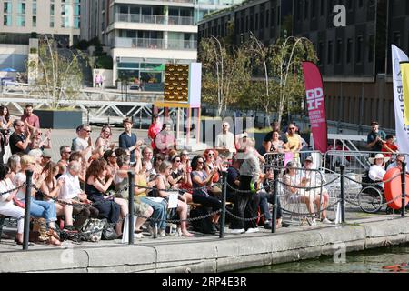 London, Großbritannien. September 2023. Darsteller der niederländischen Gruppe Vloeistof präsentieren das Wasserspektakel „Sliding Slope“ an den Royal Victoria Docks im Rahmen des Greenwich Docklands International Festival (GDIF) 2023. Eine Show, in der vier Menschen verzweifelt auf dem Dach eines überfluteten Hauses ums Überleben kämpfen. Inspiriert von der Nordsee-Überschwemmung von 1953, die eine verheerende historische Katastrophe angesichts des steigenden Meeresspiegels und der globalen Erwärmung auf den neuesten Stand bringt. Quelle: Waldemar Sikora / Alamy Live News Stockfoto