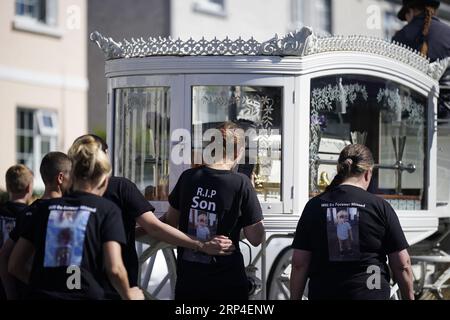 Familienmitglieder und Trauernde gehen hinter der Pferdekutsche mit dem Sarg des dreijährigen Tom Reilly, während die Särge von Thomas Reilly, 45, seiner Frau Bridget Reilly, 46, und Tom die St. John the Baptist Church in Cashel, Co. Tipperary nach ihrem Beerdigungsgottesdienst verlassen. Thomas, Bridget und Tom starben am 29. August in Cashel bei einem Unfall mit einem einzigen Fahrzeug. Bilddatum: Sonntag, 3. September 2023. Stockfoto