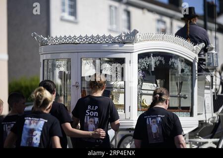 Familienmitglieder und Trauernde gehen hinter der Pferdekutsche mit dem Sarg des dreijährigen Tom Reilly, während die Särge von Thomas Reilly, 45, seiner Frau Bridget Reilly, 46, und Tom die St. John the Baptist Church in Cashel, Co. Tipperary nach ihrem Beerdigungsgottesdienst verlassen. Thomas, Bridget und Tom starben am 29. August in Cashel bei einem Unfall mit einem einzigen Fahrzeug. Bilddatum: Sonntag, 3. September 2023. Stockfoto