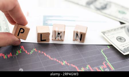 PLANEN SIE das Wort auf Holzwürfel, Würfel stehen auf einer reflektierenden Oberfläche, im Hintergrund ist ein Geschäftsdiagramm. Geschäfts- und Finanzkonzept Stockfoto