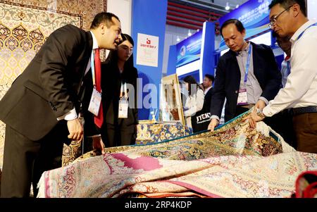 (181111) -- PEKING, 11. November 2018 -- ein iranischer Aussteller (L) stellt Teppiche auf der ersten China International Import Expo in Shanghai, Ostchina, 5. November 2018 vor. ) (Zwx) Xinhua Schlagzeilen: 1978-2018: Chinas Importgeschichte durch die Linse FangxZhe PUBLICATIONxNOTxINxCHN Stockfoto