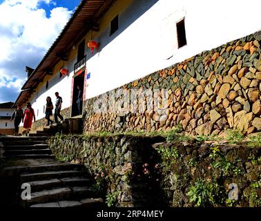 (181112) -- FUZHOU, 12. November 2018 -- Touristen besuchen den Wohnkomplex Aijing Zhuang im Dorf Yangwei im Kreis Yongtai, Provinz Fujian im Südosten Chinas, 11. November 2018. Das Projekt mit insgesamt 361 Zimmern auf einer Fläche von über 5.200 Quadratmetern wurde während der Herrschaft von Kaiser Daoguang in der Qing-Dynastie errichtet. Es hat den authentischen Charakter der traditionellen Wohnhäuser, Verteidigungsstrukturen und Wasserstraßen bewahrt, die für diese Stätte emblematisch sind und ein Modell für andere historische Dörfer in ganz China darstellen. Die Erhaltung des Wohnkomplexes Aijing Zhuang demonstriert ein Stockfoto