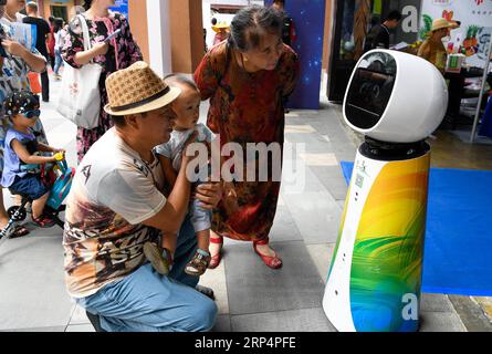 (181115) -- SANYA, 15. November 2018 -- Besucher interagieren mit einem intelligenten Roboter während der 3. Sanya International Cultural Industry Fair in Sanya, Provinz Hainan, 15. November 2018. Die Messe eröffnete hier am Donnerstag und zog Aussteller aus über 30 Ländern und Regionen entlang des Gürtels und der Straße an. ) (Gxn) CHINA-HAINAN-SANYA-CULTURAL INDUSTRY FAIR (CN) YangxGuanyu PUBLICATIONxNOTxINxCHN Stockfoto