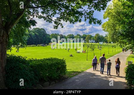 Ein entspannter, sonniger Nachmittag im Roberts Park in Saltaire am Ufer des Flusses Aire mit einem Cricket-Spiel im Gange. Stockfoto