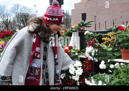 (181118) -- RIGA, 18. November 2018 -- Eine Frau legt Blumen am Denkmal der Freiheit während der hundertjährigen Unabhängigkeitsfeiern Lettlands in Riga, Lettland, am 18. November 2018. Lettland feierte seinen 100. Unabhängigkeitstag am Sonntag mit Konzerten, Gottesdiensten, einer Militärparade und zahlreichen anderen Festveranstaltungen nicht nur in der Hauptstadt Riga, sondern im ganzen Land. Die Veranstaltungen wurden anlässlich des hundertsten Jahrestages der Proklamation der Republik Lettland am 18. November 1918 abgehalten. ) LETTLAND-RIGA-UNABHÄNGIGKEIT-100. JUBILÄUMSFEIER JANIS PUBLICATIONXNOTXINXCHN Stockfoto