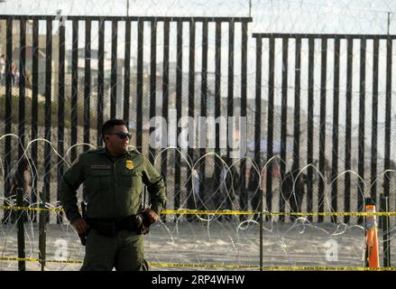 (181119) -- LOS ANGELES, 19. November 2018 -- Ein US Border Patrol Agent steht vor dem Grenzzaun, der die USA und Mexiko trennt, in San Diego, Kalifornien, USA, 17. November 2018. Die US-Beamten des Zoll- und Grenzschutzes (CBP) haben die Vorbereitungen an der Grenze zwischen den USA und Mexiko in San Diego, Kalifornien, auf die Ankunft massiver Karawanen zentralamerikanischer Migranten verschärft. )(wyo) U.S.-SAN DIEGO-BORDER ZAUN-MIGRANTS ZhaoxHanrong PUBLICATIONxNOTxINxCHN Stockfoto