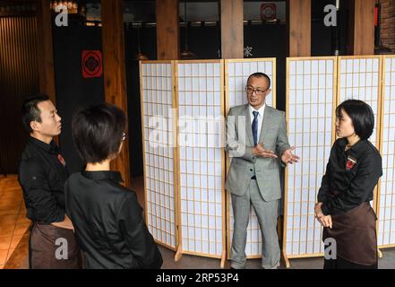 (181126) -- NANJING, 26. November 2018 -- der Japaner Kazuhiro Tozawa spricht mit Mitarbeitern in seinem Grillrestaurant in Xinjiekou von Nanjing, Hauptstadt der ostchinesischen Provinz Jiangsu, 16. Oktober 2018. Kazuhiro Tozawa, 45, betreibt ein Barbecue-Restaurant in Xinjiekou in Nanjing. Er kam 1996 nach Nanjing, um traditionelle chinesische Medizin zur Behandlung seiner eigenen Krankheit zu erlernen. Kazuhiro Tozawa ist seit 22 Jahren in Nanjing und liebt die Stadt und findet hier viele Freunde. Er betrachtet Nanjing als seine Heimatstadt, wo er für den Rest seines Lebens bleiben wird. ) (ZWX) CHINA-JIANGSU-NANJING-JAPANESE-HOMETOWN (CN) JIXCH Stockfoto