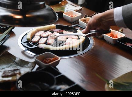 (181126) -- NANJING, 26. November 2018 -- der japanische Kazuhiro Tozawa röstet Fleisch für Kunden in seinem Barbecue-Restaurant in Xinjiekou in Nanjing, Hauptstadt der ostchinesischen Provinz Jiangsu, 16. Oktober 2018. Kazuhiro Tozawa, 45, betreibt ein Barbecue-Restaurant in Xinjiekou in Nanjing. Er kam 1996 nach Nanjing, um traditionelle chinesische Medizin zur Behandlung seiner eigenen Krankheit zu erlernen. Kazuhiro Tozawa ist seit 22 Jahren in Nanjing und liebt die Stadt und findet hier viele Freunde. Er betrachtet Nanjing als seine Heimatstadt, wo er für den Rest seines Lebens bleiben wird. ) (ZWX) CHINA-JIANGSU-NANJING-JAPANESE-HOMETOWN (CN) JIX Stockfoto