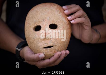 (181128) -- JERUSALEM, 28. November 2018 -- Ronit Lupu, ein Archäologe der Israel Antiquities Authority (IAA), hält am 28. November 2018 eine Steinmaske im Rockefeller Museum in Jerusalem. Eine seltene prähistorische Steinmaske, die aus der Zeit vor 9.000 Jahren stammt, wurde im südlichen Westjordanland entdeckt, sagte die Israel Antiquities Authority am Mittwoch. MIDEAST-JERUSALEM-IAA-VORGESCHICHTLICHE STEINMASKENENTDECKUNG JINI PUBLICATIONXNOTXINXCHN Stockfoto