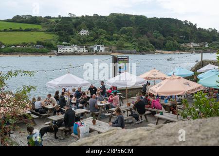 Blick auf den bepackten Biergarten des Ferry Pub in Salcombe mit spektakulärem Blick über den Hafen nach East Portlemouth auf der anderen Seite Stockfoto