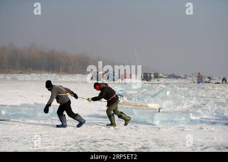 (181212) -- HARBIN, 12. Dezember 2018 -- Arbeiter tragen Eiswürfel, die vom gefrorenen Songhua-Fluss in Harbin, der Hauptstadt der nordöstlichen Provinz Heilongjiang, am 12. Dezember 2018 gesammelt wurden. Die Arbeiter hier sind organisiert, um Eiswürfel vom gefrorenen Songhua River zu sammeln, um sich auf den Bau der Eis- und Schneelandschaft vor kurzem vorzubereiten. ) (Yxb) CHINA-HEILONGJIANG-HARBIN-ICE COLLECTING (CN) WangxKai PUBLICATIONxNOTxINxCHN Stockfoto