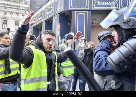 (181215) -- PARIS, 15. Dezember 2018 -- Gelbwesten-Demonstranten stellen sich französischen Gendarmen am 15. Dezember 2018 auf dem Opernplatz in Paris. Die französische Regierung plante harte Sicherheitsmaßnahmen, indem sie Tausende von Offizieren mobilisierte und gepanzerte Fahrzeuge einsetzte, um gegen weitere Gewaltandrohungen vorzugehen, während die Gelben Westen am Samstag eine neue Runde landesweiter Proteste veranstalten. trotz der Maßnahmen von Präsident Emmanuel Macron, die die öffentliche Wut über schlechte Einnahmen und hohe Lebenshaltungskosten unterdrücken sollen. ) FRANKREICH-PARIS-GELBE WESTEN -PROTEST ChenxYichen PUBLICATIONxNOTxINxCHN Stockfoto