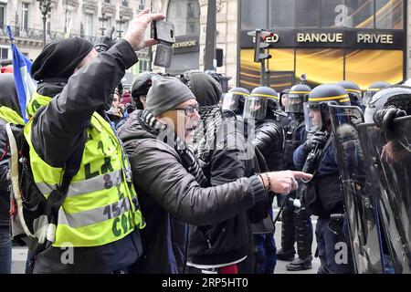 (181215) -- PARIS, 15. Dezember 2018 -- Demonstranten stellen sich französischen Gendarmen am 15. Dezember 2018 auf dem Opernplatz in Paris. Die französische Regierung plante harte Sicherheitsmaßnahmen, indem sie Tausende von Offizieren mobilisierte und gepanzerte Fahrzeuge einsetzte, um gegen weitere Gewaltandrohungen vorzugehen, während die Gelben Westen am Samstag eine neue Runde landesweiter Proteste veranstalten. trotz der Maßnahmen von Präsident Emmanuel Macron, die die öffentliche Wut über schlechte Einnahmen und hohe Lebenshaltungskosten unterdrücken sollen. ) FRANKREICH-PARIS-GELBE WESTEN -PROTEST ChenxYichen PUBLICATIONxNOTxINxCHN Stockfoto