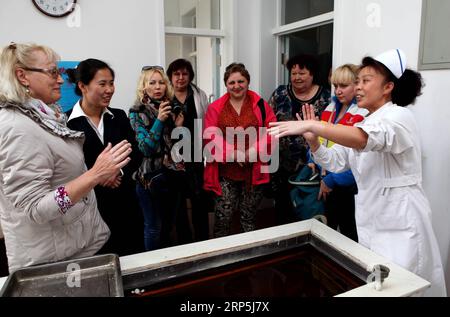 (181216) -- PEKING, 16. Dezember 2018 -- Mitglieder einer Delegation eines russischen Reisebüros erleben Wachstherapie der traditionellen chinesischen Medizin (TCM) in einem Sanatorium in der Stadt Xingcheng, Provinz Liaoning im Nordosten Chinas, 16. April 2014. Experten, die an einem Tourismusforum in Peking am 12. Dezember 2018 teilnahmen, sagten, dass der Gesundheitstourismus mit der traditionellen chinesischen Medizin (TCM) eine goldene Zeit für Entwicklung einläutet. Auf dem Forum kündigte der Weltverband der chinesischen Medizingesellschaften die Einrichtung eines Sonderausschusses zur Förderung des Gesundheitstourismus weltweit an. TCM Gesundheitstourismus bietet Touris Stockfoto