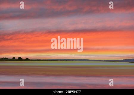 Pastellfarbener Himmel bei Sonnenuntergang und Wasserreflexe. Palo Alto Baylands, Kalifornien, USA. Stockfoto