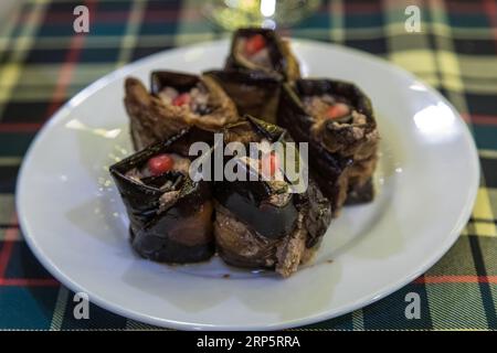 Auberginen-Roulade gefüllt mit Walnüssen und Granatapfelfrüchten mit Knoblauch und georgianischen Gewürzen. Stockfoto