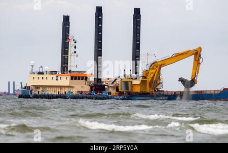 Lubmin, Deutschland. September 2023. Ein Bagger arbeitet vor dem Industriehafen Lubmin, um die Baggerarbeiten für den Bau des Rohrgrabens im zugelassenen Abschnitt des Sees fortzusetzen. Die Verlegung der Anschlussleitung für das umstrittene Rügener LNG-Terminal soll in Kürze beginnen. Das notwendige Spezialschiff „Castoro 10“ ist jedoch noch nicht in Position. Quelle: Stefan sauer/dpa/Alamy Live News Stockfoto