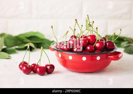Frisch geerntete Kirschen in einer Schüssel. Frische süße Bio-Kirschen in einer roten Schüssel. Stockfoto