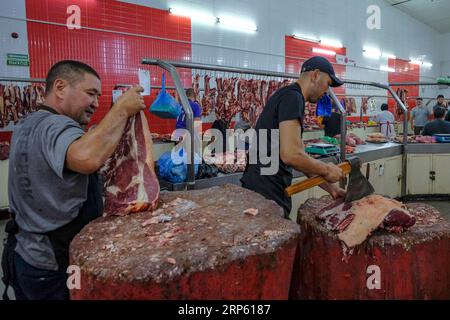 Bischkek, Kirgisistan - 2. September 2023: Ein Mann, der Fleisch im Osch-Basar in Bischkek, Kirgisistan, verkauft. Stockfoto