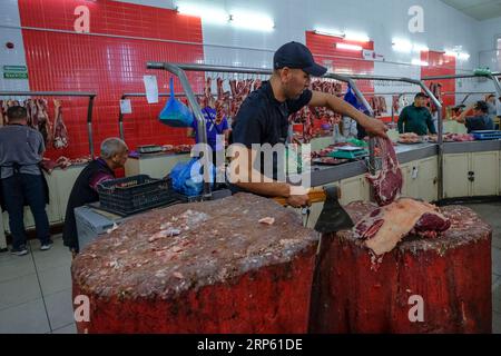 Bischkek, Kirgisistan - 2. September 2023: Ein Mann, der Fleisch im Osch-Basar in Bischkek, Kirgisistan, verkauft. Stockfoto