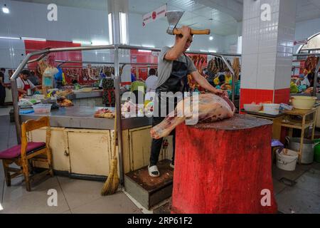 Bischkek, Kirgisistan - 2. September 2023: Ein Mann, der Fleisch im Osch-Basar in Bischkek, Kirgisistan, verkauft. Stockfoto