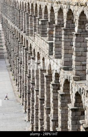 Blick auf Segovias römisches Aquädukt, mit winzigen menschlichen Figuren im Verhältnis Stockfoto