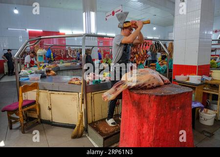 Bischkek, Kirgisistan - 2. September 2023: Ein Mann, der Fleisch im Osch-Basar in Bischkek, Kirgisistan, verkauft. Stockfoto