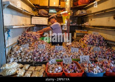 Bischkek, Kirgisistan - 2. September 2023: Ein Mann, der Knoblauch im Osch-Basar in Bischkek, Kirgisistan, verkauft. Stockfoto