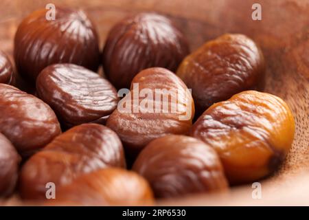 Geröstete, geschälte und köstliche Kastanienfrüchte in einer Holzschale. Makro Stockfoto