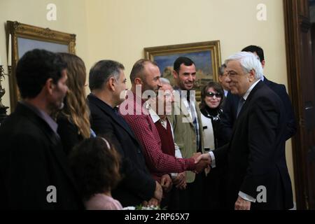 (190103) -- ATHEN, 3. Januar 2019 -- der griechische Präsident Prokopis Pavlopoulos (1. R) trifft sich und gratuliert den drei Fischern und ihren Familien in der Präsidentenvilla in Athen, Griechenland, 2. Januar 2019. Die Ägypter Emand El Khamisi (50), Mahmoud Moussa (46) und der Albaner Jeka Gani (35) riskierten am 23. Juli 2018 neben vielen anderen einheimischen Fischern ihr Leben und retteten Dutzende von Menschen, die vor der Flamme flohen, die durch den Badeort Mati, etwa 30 Kilometer nordöstlich von Athen, fegte. Hundert Menschen starben an diesem Abend in den Flammen oder im Meer. Der griechische Präsident Prokopis Pavlopoulos unterzeichnete a f Stockfoto