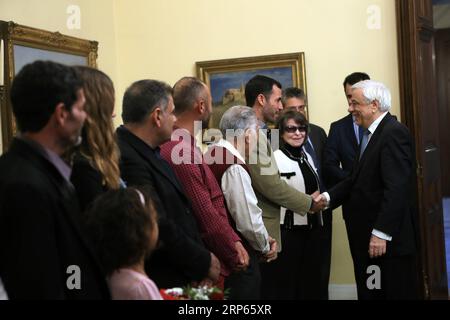 (190103) -- ATHEN, 3. Januar 2019 -- der griechische Präsident Prokopis Pavlopoulos (1. R) trifft sich und gratuliert den drei Fischern und ihren Familien in der Präsidentenvilla in Athen, Griechenland, 2. Januar 2019. Die Ägypter Emand El Khamisi (50), Mahmoud Moussa (46) und der Albaner Jeka Gani (35) riskierten am 23. Juli 2018 neben vielen anderen einheimischen Fischern ihr Leben und retteten Dutzende von Menschen, die vor der Flamme flohen, die durch den Badeort Mati, etwa 30 Kilometer nordöstlich von Athen, fegte. Hundert Menschen starben an diesem Abend in den Flammen oder im Meer. Der griechische Präsident Prokopis Pavlopoulos unterzeichnete a f Stockfoto