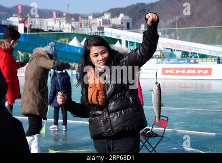 (190105) -- HWACHEON, 5. Januar 2019 -- Eine Frau zeigt eine Forelle, die sie während des Sancheoneo Ice Festivals in Hwacheon, Südkorea, am 5. Januar 2019 auf einem gefrorenen Fluss gefangen hat. Als eines der größten Winterereignisse Südkoreas zieht das jährliche dreiwöchige Festival die Menschen zum gefrorenen Hwacheon-Fluss, wo die Organisatoren während der Festivalzeit Angellöcher im Eis bohren und Forellen in den Fluss werfen. Dieses Jahr dauert das Festival vom 5. Januar bis 27. Januar. ) SÜDKOREA-HWACHEON-SANCHEONEO ICE FESTIVAL WANGXJINGQIANG PUBLICATIONXNOTXINXCHN Stockfoto