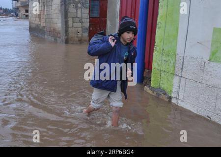 (190108) -- BEIRUT, 8. Januar 2019 (Xinhua) -- Ein Flüchtlingsjunge läuft im Hochwasser in einem syrischen Flüchtlingslager am Rande von Tripoli, Libanon, 8. Januar 2019. Die syrischen Flüchtlinge, die in Zelten im Libanon leben, haben mehr gelitten, da ein großer Sturm, genannt Norma, in vielen Gebieten des Landes schwere Schäden verursacht. (Xinhua/Khalid) LIBANON-TRIPOLI-WETTEREXTREME-SYRISCHE FLÜCHTLINGE PUBLICATIONxNOTxINxCHN Stockfoto