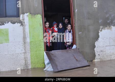 (190108) -- BEIRUT, 8. Januar 2019 (Xinhua) -- Eine Flüchtlingsfamilie wird in einem von Überschwemmungen umgebenen Haus in einem syrischen Flüchtlingslager am Rande von Tripoli, Libanon, 8. Januar 2019 gesehen. Die syrischen Flüchtlinge, die in Zelten im Libanon leben, haben mehr gelitten, da ein großer Sturm, genannt Norma, in vielen Gebieten des Landes schwere Schäden verursacht. (Xinhua/Khalid) LIBANON-TRIPOLI-WETTEREXTREME-SYRISCHE FLÜCHTLINGE PUBLICATIONxNOTxINxCHN Stockfoto