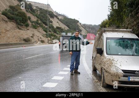 (190114) -- BEIRUT, 14. Januar 2019 -- Ein Fahrer parkt sein Auto auf einer Straße, die durch einen Erdrutsch auf der Autobahn von der nördlichen Stadt Batroun nach Chekka im Libanon, 14. Januar 2019, unterbrochen wurde. Der Erdrutsch wurde durch Starkregen über Nacht verursacht. ) LIBANON-BATROUN-ERDRUTSCH Khalid PUBLICATIONxNOTxINxCHN Stockfoto