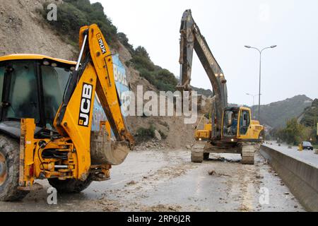 (190114) -- BEIRUT, 14. Januar 2019 -- Arbeiter fahren Bagger, um eine Straße zu räumen, die durch einen Erdrutsch auf der Autobahn von der nördlichen Stadt Batroun nach Tschekka im Libanon, 14. Januar 2019, geschnitten wurde. Der Erdrutsch wurde durch Starkregen über Nacht verursacht. ) LIBANON-BATROUN-ERDRUTSCH Khalid PUBLICATIONxNOTxINxCHN Stockfoto