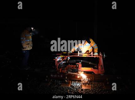 (190117) -- HUANGSHAN, 17. Januar 2019 (Xinhua) -- Ein Bauarbeiter schneidet Stahlschienen am Huangshan Nordbahnhof auf der Hangzhou-Huangshan Hochgeschwindigkeitsbahn in der Stadt Huangshan, ostchinesische Provinz Anhui, 17. Januar 2019. Bauarbeiter des Jixi North Fixing Abschnitts der China Railway Shanghai Group Co., ltd., von denen die meisten in den 1990er Jahren geboren wurden und die ihre Arbeit vor der offiziellen Eröffnung der Hangzhou-Huangshan-Hochgeschwindigkeitsbahn begannen, sind für die Befestigung von Hochgeschwindigkeitsschienen im Bergregion in der südlichen Provinz Anhui verantwortlich. (Xinhua/Liu Junxi) CHINA-ANHUI-HUANGSHAN-RAILWA Stockfoto