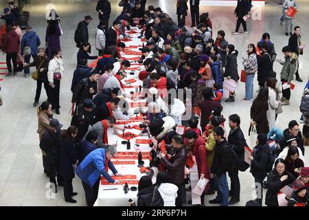 (190118) -- HANGZHOU, 18. Januar 2019 (Xinhua) -- Kalligraphen schreiben chinesische Schriftzeichen Fu oder Segen auf Englisch, und Frühjahrsfest Couplets für Bürger im Zhejiang Art Museum in Hangzhou, Hauptstadt der ostchinesischen Provinz Zhejiang, 17. Januar 2019. Die Chinesen kleben normalerweise Frühlingsfest-Couplets auf die beiden Seiten einer Tür, um ihre Wünsche und Grüße für das neue Jahr ab dem ersten Tag des ersten Monats des Mondkalenders oder dem 5. Februar dieses Jahres auszudrücken. (Xinhua/Li Zhong) CHINA-SPRING FESTIVAL COUPLETS (CN) PUBLICATIONxNOTxINxCHN Stockfoto