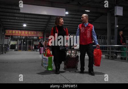 (190121) -- SHENZHEN, 21. Januar 2019 (Xinhua) -- Ein Freiwilliger (R) hilft einem Passagier beim Tragen von Gepäck am Shenzhen West Railway Station in Shenzhen, südchinesische Provinz Guangdong, 20. Januar 2019. Hunderte Millionen Chinesen kehren jedes Jahr zum Lunar New Year oder Spring Festival, Familientreffen, in ihre Heimatorte zurück und bilden so den Reisetag des Spring Festivals. Das Frühlingsfest beginnt am 5. Februar dieses Jahres. Am 21. Januar 2019 begann der 40-tägige Reiserouch des Spring Festivals, bei dem 3 Milliarden Reisen erwartet wurden. (Xinhua/Mao Siqian) CHINA-SPRING FESTIVAL-TRAVEL RUSH (CN) PUBLICATIONxNOT Stockfoto