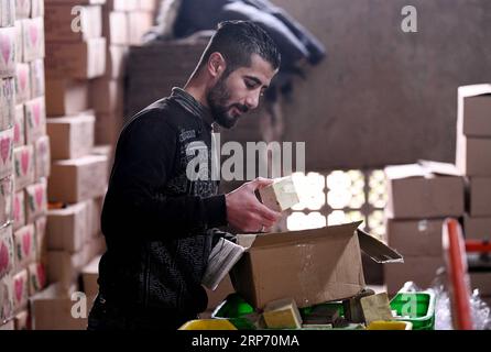 (190123) -- ALEPPO, 23. Januar 2019 -- Ein syrischer Arbeiter packt die Olivenseifenstangen in einer Fabrik am Stadtrand von Aleppo, Syrien, 20. Dezember 2018. Für die Menschen in der syrischen Stadt Aleppo ist die Olivenseife nicht nur ein Seifenriegel zum Händewaschen oder zum natürlichen Schimmer der Haare, sondern auch eines ihrer stolzen und geschätzten Erbes. DAZU NOCH: Olivenseifenhersteller, die in Solidarität zusammengeschlossen sind, um die traditionelle Industrie in Aleppo in Syrien WIEDERZUBELEBEN) SYRIEN-ALEPPO-LIFE-OLIVE-SOAP-MAKING AmmarxSafarjalani PUBLICATIONxNOTxINxCHN Stockfoto