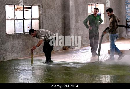 (190123) -- ALEPPO, 23. Januar 2019 -- syrische Arbeiter gießen eine Mischung aus Olivenöl und Lorbeeröl zur Herstellung von Olivenseife in einer Fabrik am Rande der Stadt Aleppo, Syrien, 20. Dezember 2018. Für die Menschen in der syrischen Stadt Aleppo ist die Olivenseife nicht nur ein Seifenriegel zum Händewaschen oder zum natürlichen Schimmer der Haare, sondern auch eines ihrer stolzen und geschätzten Erbes. DAZU NOCH: Olivenseifenhersteller, die in Solidarität zusammengeschlossen sind, um die traditionelle Industrie in Aleppo in Syrien WIEDERZUBELEBEN) SYRIEN-ALEPPO-LIFE-OLIVE-SOAP-MAKING AmmarxSafarjalani PUBLICATIONxNOTxINxCHN Stockfoto