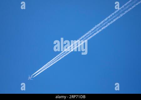 Ein Passagierflugzeug mit Kondensstreifen oder Dampflok gegen den klaren blauen Himmel in Bangladesch. Stockfoto