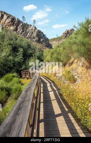 Blick auf die Penedo Furado Gehwege in der Nähe von Vila de Rei in Portugal, mit den majestätischen Klippen im Hintergrund an einem sonnigen Frühlingstag. Stockfoto