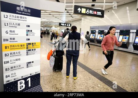 (190126) -- HONG KONG, 26. Januar 2019 (Xinhua) -- Passagiere gehen am West Kowloon Bahnhof in Hong Kong, Südchina, 25. Januar 2019. Um die Passagiere besser an den Automaten bedienen zu können, sind blaue Schilder angebracht und Mitarbeiter in Orange werden am Bahnhof West Kowloon in Hongkong zur Hilfe geschickt. (Xinhua/Wu Xiaochu) CHINA-HONG KONG-WEST KOWLOON STATION-SERVICE (CN) PUBLICATIONxNOTxINxCHN Stockfoto