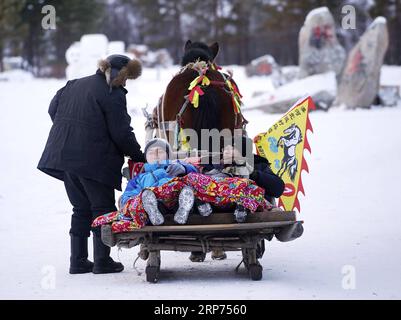 (190128) -- PEKING, 28. Januar 2019 (Xinhua) -- zwei Touristen lagen auf einer Kutsche im Dorf Beiji der Stadt Mohe, nordöstliche Provinz Heilongjiang, 24. Januar 2019. (Xinhua/Cai Yang) XINHUA FOTOS DES TAGES PUBLICATIONxNOTxINxCHN Stockfoto