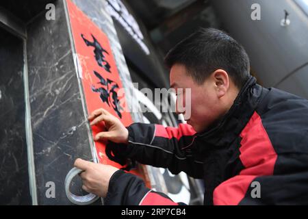 (190203) -- XI AN, 3. Februar 2019 (Xinhua) -- Deliveryman Luo Feilong pastet ein Frühjahrs-Festival-Couplet in einem Vertriebszentrum in Xi an, Hauptstadt der nordwestchinesischen Provinz Shaanxi, 3. Februar 2019. Luo Feilong, ein 31-jähriger Lieferer aus der Provinz Shaanxi, liefert seit vier Jahren Pakete in einer Gemeinde von Xi an. Luo bewarb sich während des diesjährigen Frühlingsfests um Dienstbereitschaft, damit andere Helfer aus der Provinz zu Familientreffen in ihre Heimatorte zurückkehren können. (Xinhua/Zhang Bowen) CHINA-XI AN-SPRING FESTIVAL-DELIVERYMAN (CN) PUBLICATIONxNOTxINxCHN Stockfoto